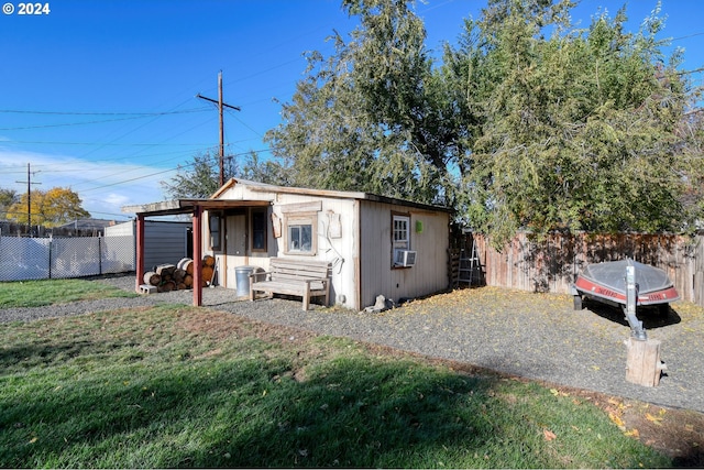 view of front of property featuring a front lawn, an outbuilding, and cooling unit