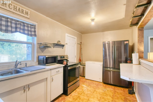 kitchen featuring stainless steel appliances, white cabinetry, and sink