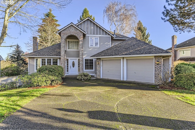 10420 SW 153rd Ave, Beaverton, OR 97007 - traditional home featuring an attached garage, board and batten siding, asphalt driveway, and brick siding
