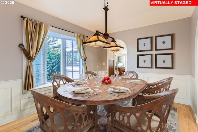 10420 SW 153rd Ave, Beaverton, OR 97007 - dining space with wainscoting, a decorative wall, light wood-type flooring, and arched walkways