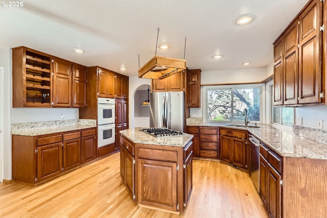 kitchen with sink, light hardwood / wood-style floors, a center island, and appliances with stainless steel finishes