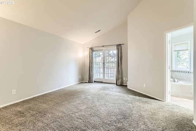 carpeted empty room featuring high vaulted ceiling