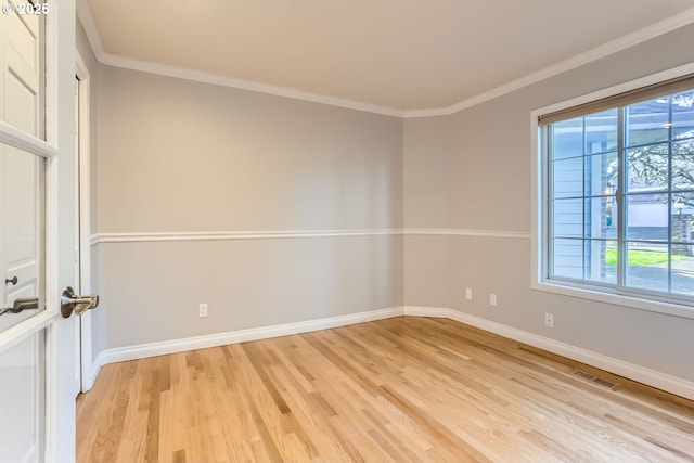 unfurnished room with ornamental molding and light wood-type flooring