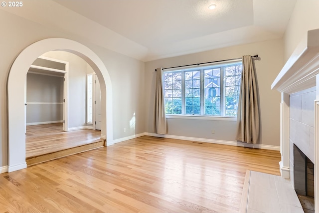 10420 SW 153rd Ave, Beaverton, OR 97007 - unfurnished living room featuring arched walkways, light wood-type flooring, and baseboards