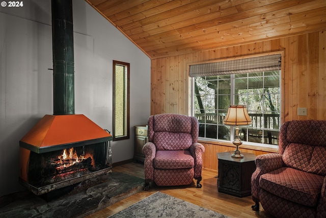 sitting room with lofted ceiling, wooden walls, wood ceiling, and wood-type flooring