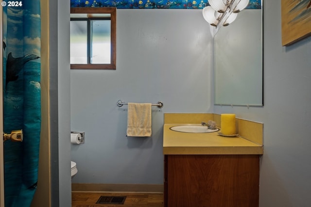 bathroom featuring vanity, hardwood / wood-style floors, and toilet