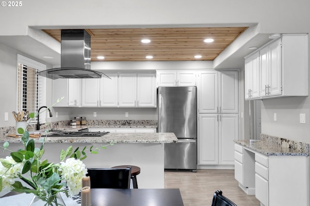 kitchen featuring freestanding refrigerator, island range hood, recessed lighting, wood ceiling, and white cabinets