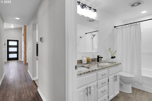 full bathroom featuring visible vents, double vanity, toilet, baseboards, and a sink