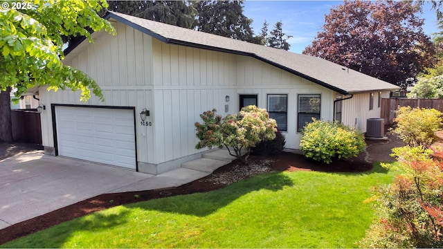 view of side of property featuring fence, a shingled roof, central AC unit, concrete driveway, and a lawn