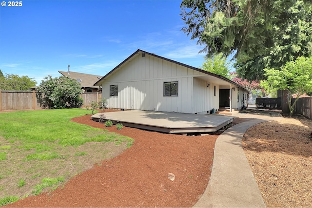 view of front of house featuring a deck, a fenced backyard, and a front yard
