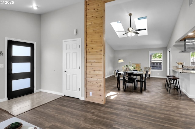 entryway featuring visible vents, baseboards, dark wood-style floors, high vaulted ceiling, and a skylight