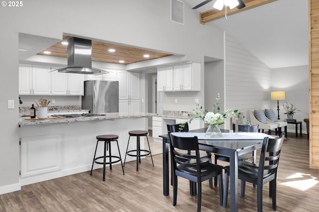 dining room featuring ceiling fan, light wood-style flooring, recessed lighting, beamed ceiling, and visible vents