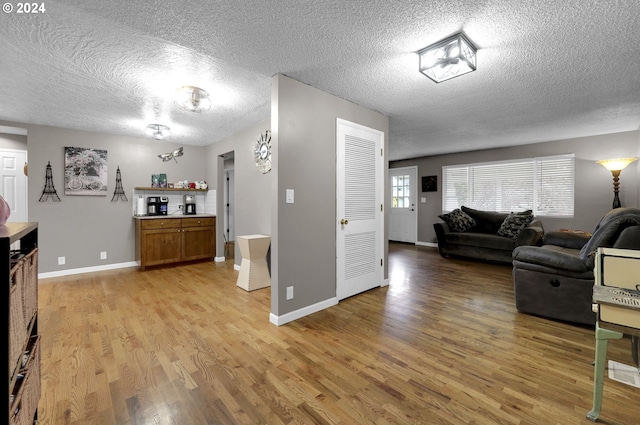 living room featuring a textured ceiling and light hardwood / wood-style flooring