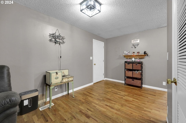 living area featuring hardwood / wood-style flooring and a textured ceiling