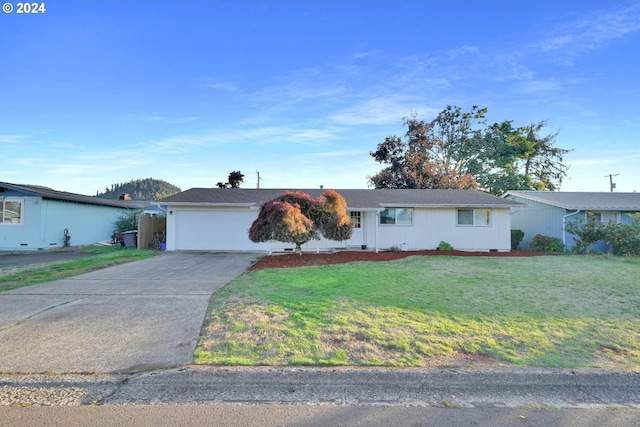 ranch-style home featuring a garage and a front lawn