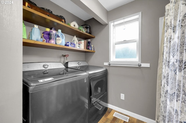 washroom featuring dark hardwood / wood-style flooring and washer and clothes dryer