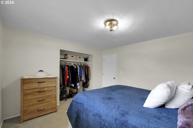 carpeted bedroom with a textured ceiling and a closet