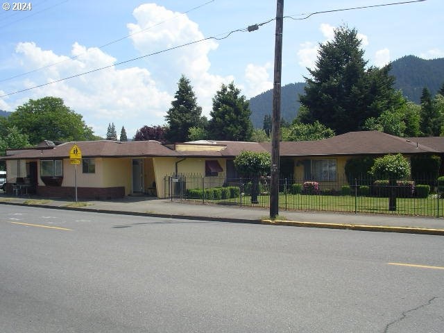 ranch-style home with a fenced front yard and a mountain view