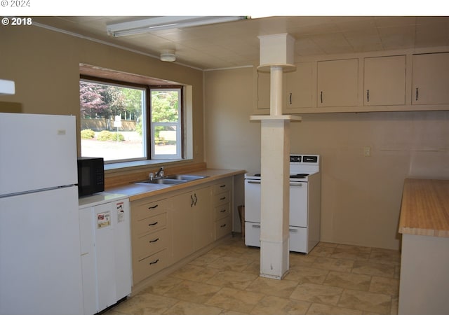 kitchen featuring a sink, white appliances, ornamental molding, and light countertops