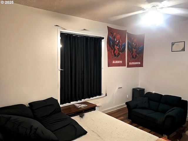 bedroom with ceiling fan, baseboards, and wood finished floors