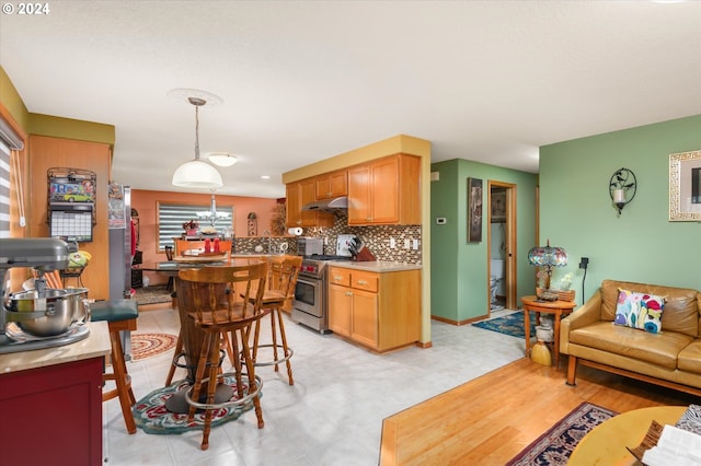 3824 Brighton Ave, Eugene, OR 97405 - kitchen with high end range, under cabinet range hood, backsplash, light countertops, and hanging light fixtures
