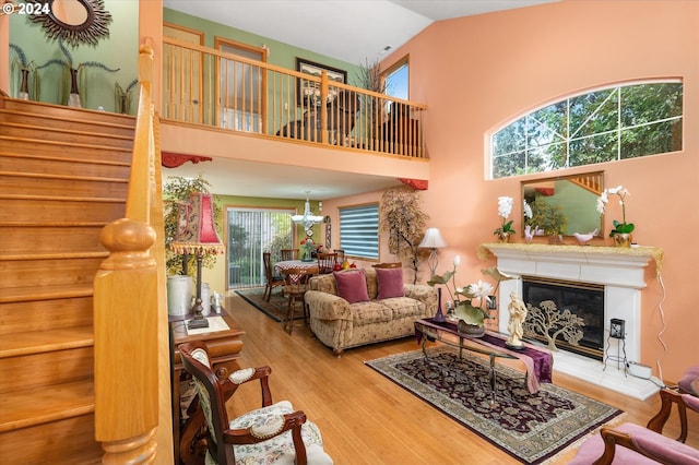 3824 Brighton Ave, Eugene, OR 97405 - living area featuring wood finished floors, a glass covered fireplace, vaulted ceiling, and stairs