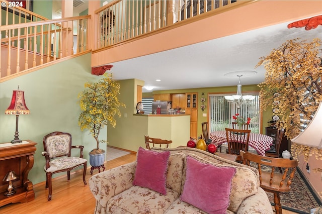 3824 Brighton Ave, Eugene, OR 97405 - living area featuring a chandelier, light wood-style flooring, baseboards, stairs, and a high ceiling