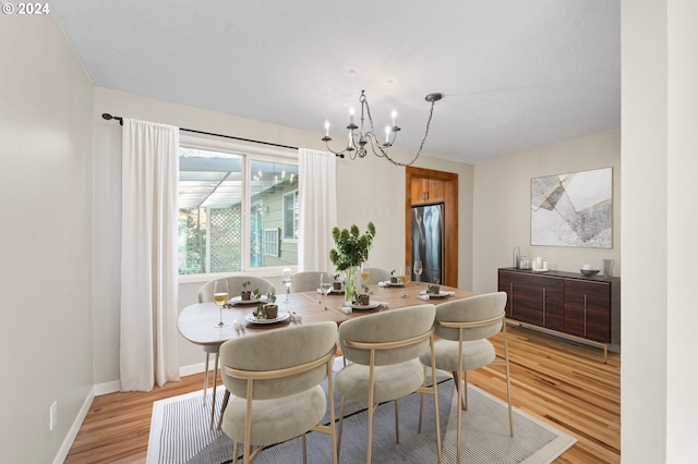 dining space featuring a notable chandelier and light wood-type flooring