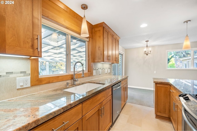 kitchen featuring sink, pendant lighting, plenty of natural light, and appliances with stainless steel finishes