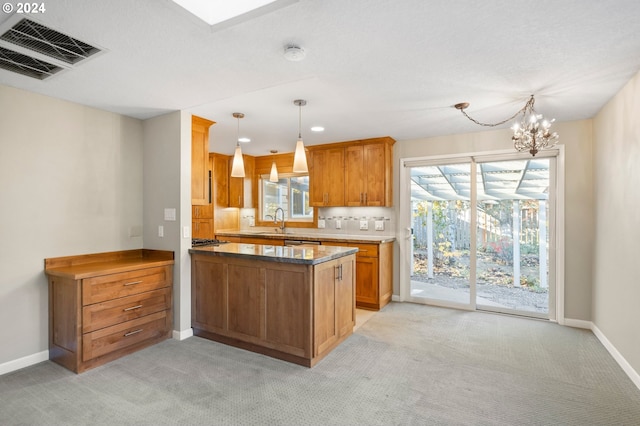 kitchen featuring sink, hanging light fixtures, a notable chandelier, light colored carpet, and kitchen peninsula