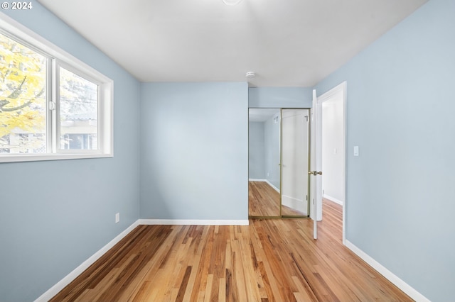 unfurnished bedroom featuring a closet and light hardwood / wood-style flooring