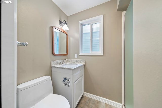 bathroom featuring tile patterned flooring, vanity, and toilet