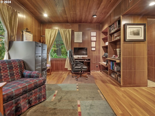 office space featuring light hardwood / wood-style floors, wooden walls, and built in features