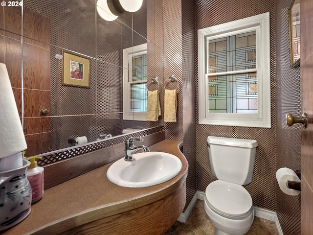 bathroom featuring toilet, a sink, and baseboards