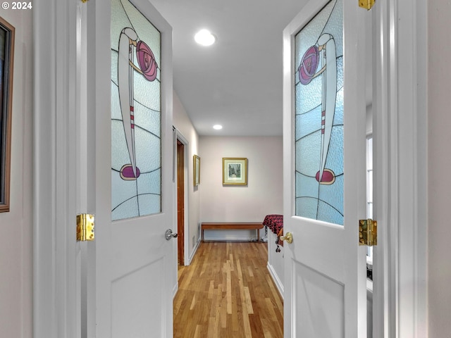 doorway with light wood finished floors, baseboards, and recessed lighting