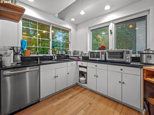kitchen featuring a sink, a toaster, stainless steel appliances, light wood-style flooring, and white cabinetry
