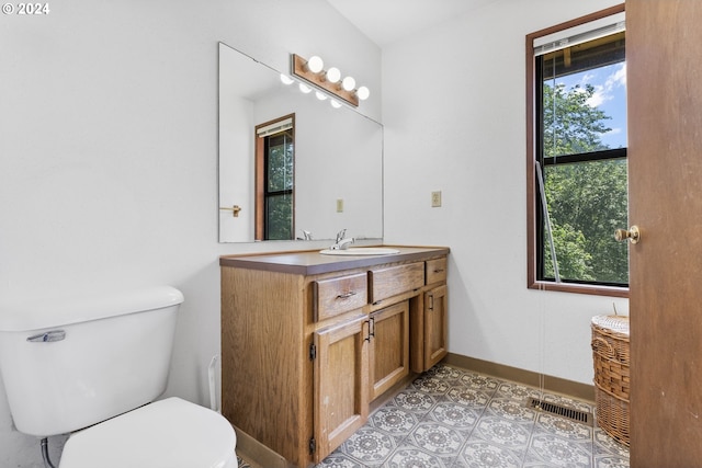 bathroom featuring a wealth of natural light, vanity, and toilet