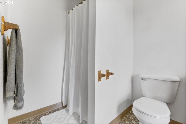 bathroom with toilet and curtained shower