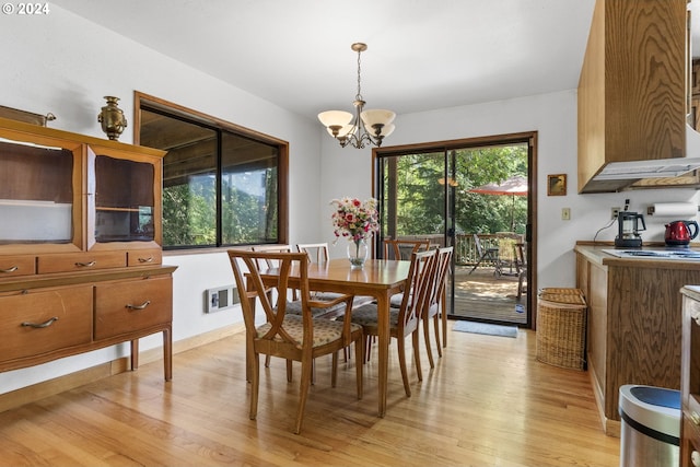 dining room featuring light wood-type flooring and a notable chandelier