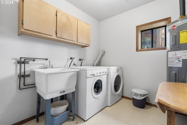 laundry room featuring washer and dryer, cabinets, and electric water heater