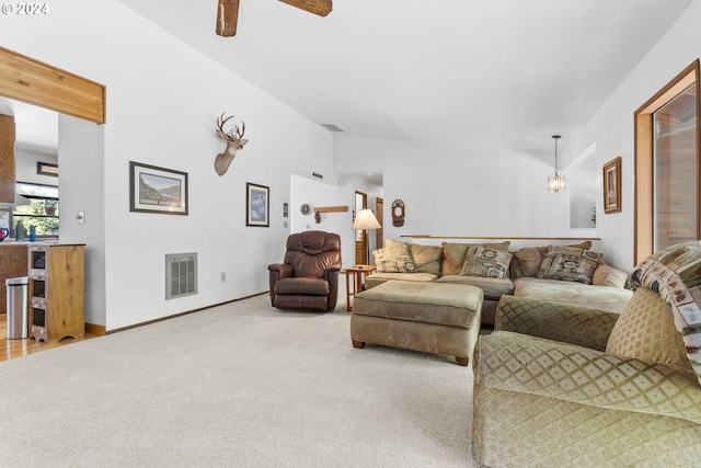 living room with lofted ceiling, ceiling fan, and carpet