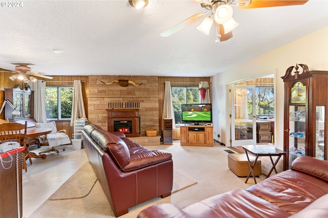 carpeted living room featuring wood walls, ceiling fan, and a wealth of natural light