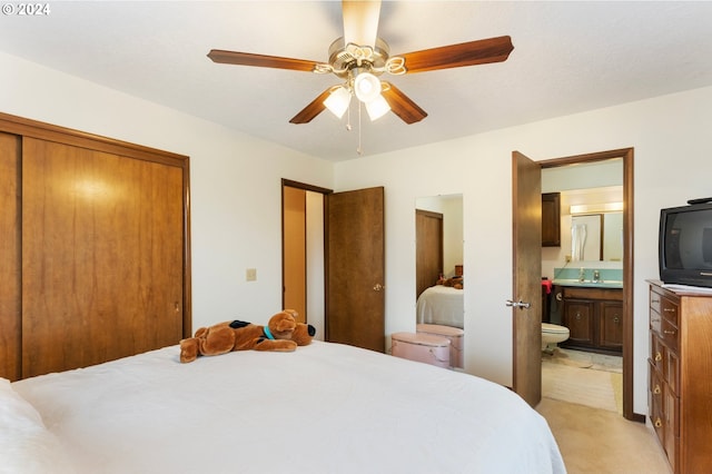 bedroom with connected bathroom, ceiling fan, light colored carpet, and sink