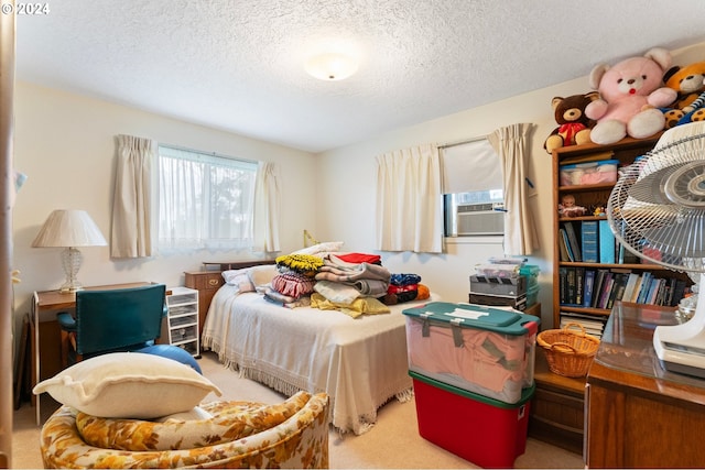 bedroom featuring light carpet, cooling unit, and a textured ceiling