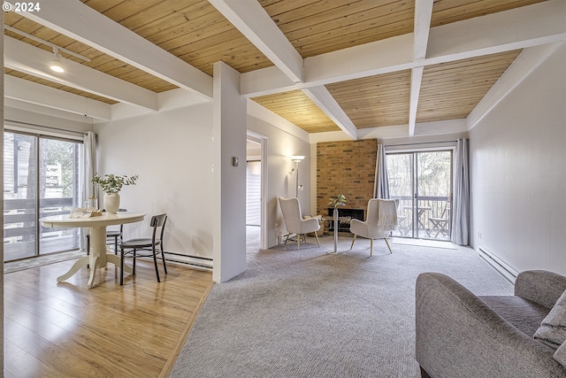 sitting room with beamed ceiling, a large fireplace, wood ceiling, and a baseboard heating unit