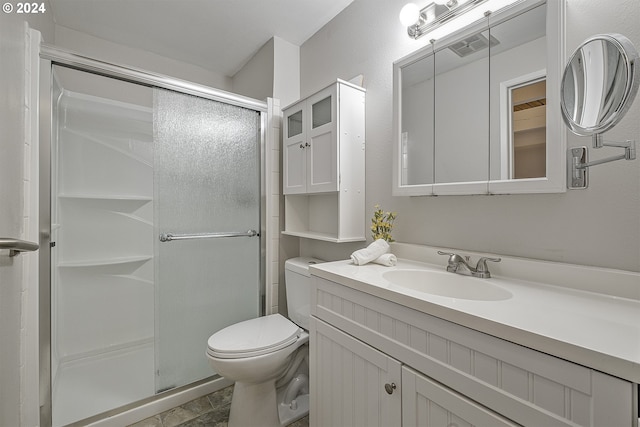 bathroom with tile patterned flooring, a shower with door, vanity, and toilet