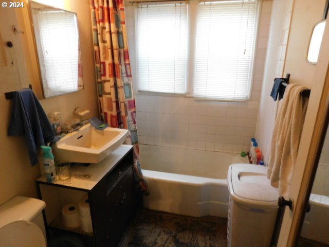 full bathroom featuring shower / tub combo, vanity, and toilet