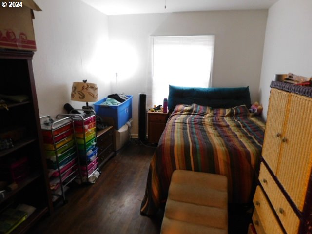 bedroom with dark hardwood / wood-style flooring