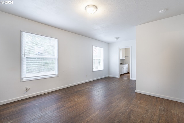 unfurnished room featuring a textured ceiling and dark wood-type flooring