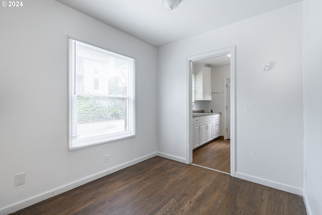 unfurnished bedroom with a closet and dark hardwood / wood-style flooring